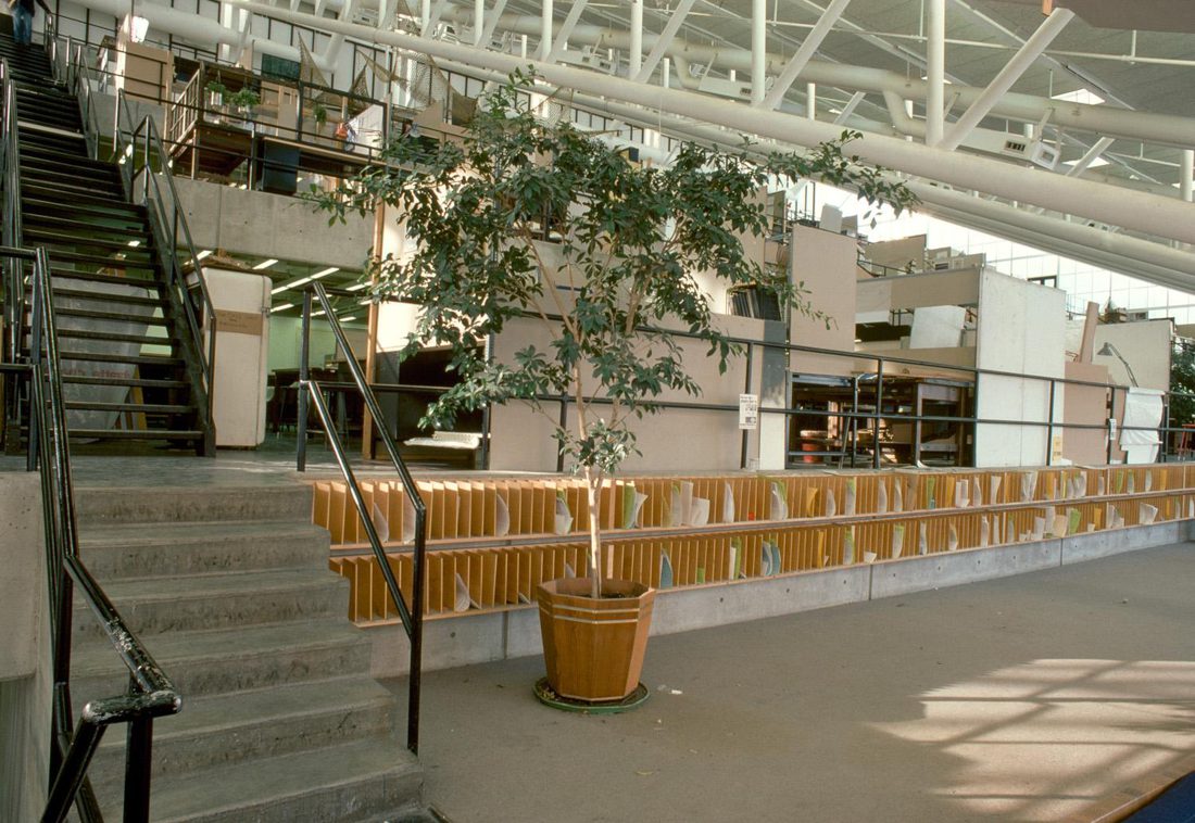The interior of Gund Hall in 1970: open concrete steps and studio trays with a single potted tree, spacious and uncrowded.